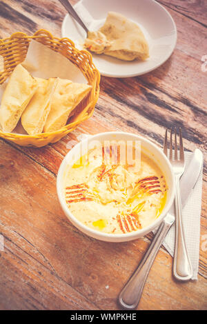 Hummus pürierte Kichererbsen, Tahini, Zitrone, Knoblauch beträufelt mit extra natives Öl mit Fladenbrot serviert. Stockfoto