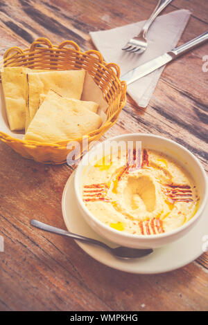 Hummus pürierte Kichererbsen, Tahini, Zitrone, Knoblauch beträufelt mit extra natives Öl mit Fladenbrot serviert. Stockfoto