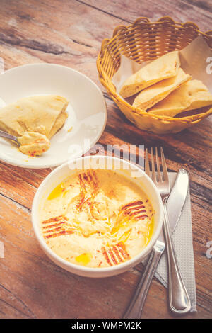 Hummus pürierte Kichererbsen, Tahini, Zitrone, Knoblauch beträufelt mit extra natives Öl mit Fladenbrot serviert. Stockfoto