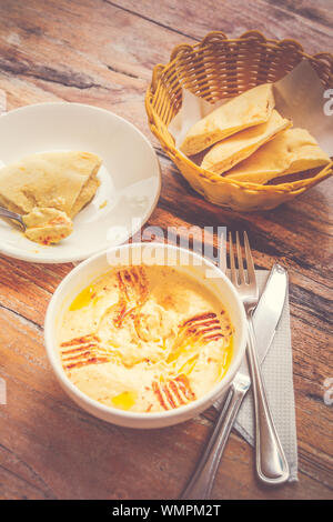 Hummus pürierte Kichererbsen, Tahini, Zitrone, Knoblauch beträufelt mit extra natives Öl mit Fladenbrot serviert. Stockfoto