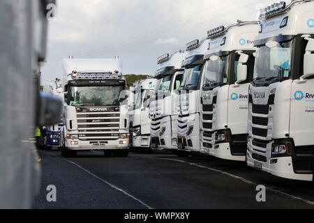 Ein Scania 164L 580 Super Lkw fahren neben einer Reihe von RiverRidge Recycling Lkw gesehen an der Causeway Coast Truckfest Stockfoto