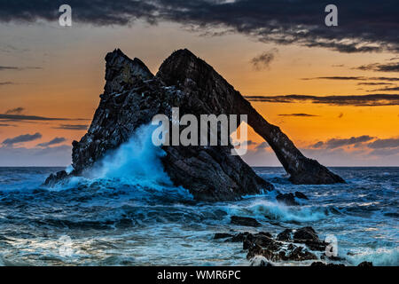 Bogen GEIGE ROCK PORTKNOCKIE Moray in Schottland PREDAWN mit stürmischen Meer und riesigen Welle und sprühen Sie schlagen auf den Felsen Stockfoto