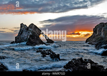 Bogen GEIGE ROCK PORTKNOCKIE Moray in Schottland Sonnenaufgang mit stürmischer See und beeindruckenden Wellen Stockfoto