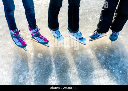 Personen, Winter Sport und Freizeit Konzept - Nahaufnahme der Beine von Schlittschuhläufer auf der Eislaufbahn Stockfoto