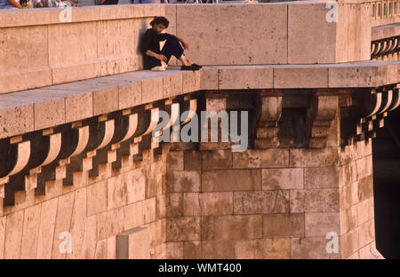 Paris, junger Mann sitzt auf einer Brücke an der Seine - Paris, Junge sitzt auf einer Brücke Stockfoto