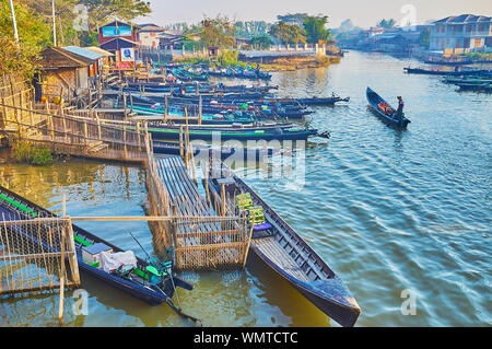 NYAUNGSHWE, MYANMAR - 20. Februar 2018: Der Fischereihafen am Inle See Kanal mit vielen günstig Kanus der örtlichen Bauern und Reisebüros auf Februar Stockfoto