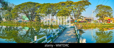 Panorama der Tharzi Teich mit alten hölzernen Brücke, seine Banken anschließen, bedeckt mit Verbreitung Bäume, Nyaungshwe, Myanmar Stockfoto