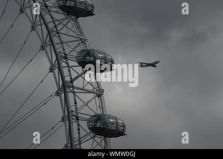 London, Großbritannien. 5. Sep 2019. Ein kommerzielles Flugzeug fliegt über das London Eye bei bewölktem Himmel mit gemischten Herbst Wetter in London. Credit: Amer Ghazzal/SOPA Images/ZUMA Draht/Alamy leben Nachrichten Stockfoto