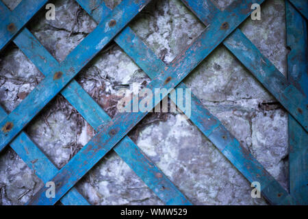 Vintage blau lackierten Holz- Gitter auf einer alten Steinmauer Stockfoto
