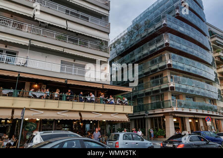 Thessaloniki, Griechenland Menschen essen an einer Stadt Taverne Balkon. Menge genießen ihre griechische Taverne essen Abendessen im Zentrum an Leoforos Nikis Avenue. Stockfoto