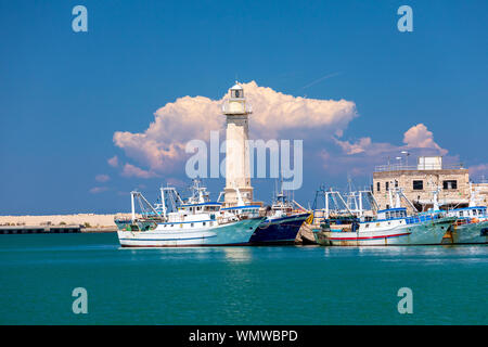 Italien, Apulien, Metropolitan Stadt Bari, Molfetta. Fischerboote und den Leuchtturm. Stockfoto