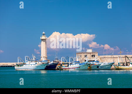 Italien, Apulien, Metropolitan Stadt Bari, Molfetta. Fischerboote und den Leuchtturm. Stockfoto