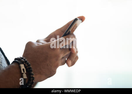 Schließen Sie herauf Bild afrikanische amerikanische mans hand Smartphone. Stockfoto