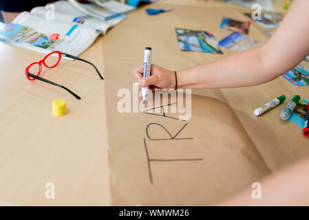 Jugendliche Hand schreiben "Reisen". Gruppenunterricht in der Reiseklasse, Englisch Schule Stockfoto