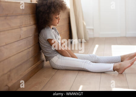 Schwarz cute kid Mädchen allein sitzen auf dem Boden umgekippt. Stockfoto