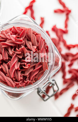 Ungekocht bunte Nudeln mit roter Bete Aroma im Glas. Ansicht von oben. Stockfoto