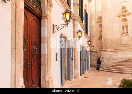 Italien, Apulien, Provinz Tarent, Martina Franca. Piazza Maria Immacolata: Person hinter der Kathedrale von Saint Martin, Basilica di San Martino. Stockfoto