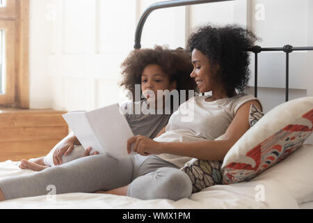 Happy einzigen gemischten Rennen Mutter Lehre cute kid zu lesen. Stockfoto