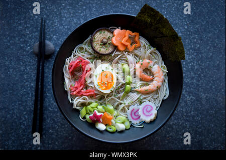 Schüssel japanischer Buchweizen Ramen Nudelsuppe mit bunten toppings Rechtschreibung 2019 in Essig eingelegte Ingwer, gekochtes Ei, Edamame Bohnen, und Garnelen Stockfoto