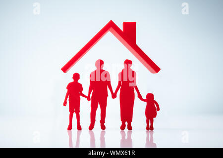 Haus Dach über Familie zahlen Silhouette auf weißem Hintergrund Stockfoto