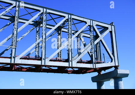 Teil der Eisenbahnbrücke auf einer konkreten Unterstützung. Glücklich, gegen den blauen Himmel. Stockfoto
