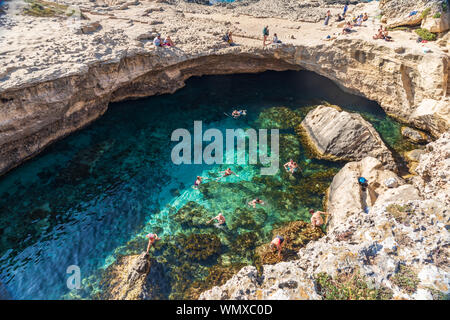 Italien, Apulien, Provinz Lecce, Melendugno. Juni 1, 2019. Menschen schwimmen in der Grotta della Poesia, ein natürlicher Pool auf den Klippen. Stockfoto