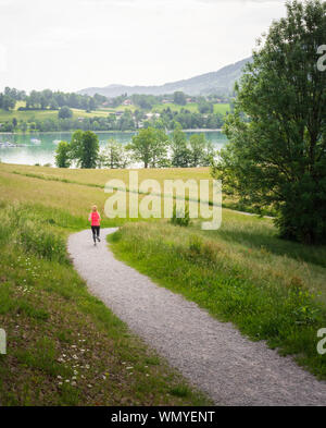 Rund um den See in den Bayerischen Alpen von Deutschland weg. Passende Frau verläuft entlang Pfad auf sonnigen Tag Stockfoto