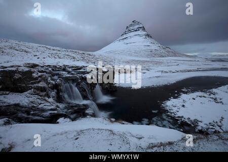 Kirkjufell und Kirkjufellsfoss im Winter, Grundarfjorour, Vesturland, Island Stockfoto