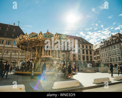 Straßburg, Frankreich - Apr 8, 2019: die Menschen Fußgänger Besucher die Stadt genießen und Merry-go-round in zentraler Ort Gutenberg Stockfoto