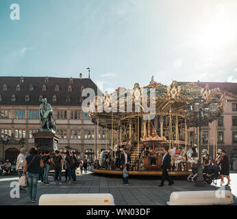 Straßburg, Frankreich - Apr 8, 2019: die Menschen Fußgänger Besucher die Stadt genießen und Merry-go-round in zentraler Ort Gutenberg Stockfoto