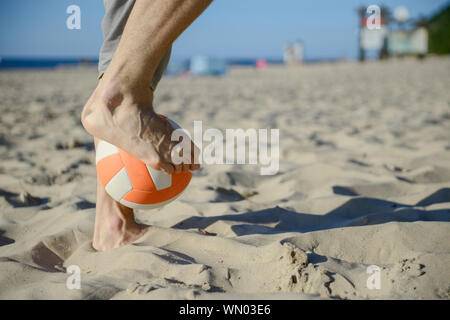 Mann, Fußball im Urlaub am Strand mit Dribbling-Fähigkeiten und Ball spielen Stockfoto