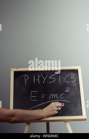 Handschriftliche Physik Wort und Formel E = mc2 auf Tafel, grauen Hintergrund Stockfoto