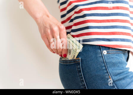 Frau Geld in Ihrer Tasche auf der Rückseite Stockfoto