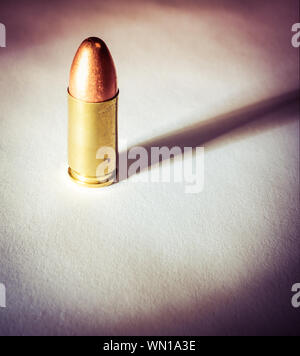 Einen einzigen Ständigen 9 mm bullet mit dramatischen Seite Licht und Schatten Stockfoto