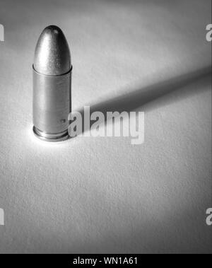 Einen einzigen Ständigen 9 mm bullet mit dramatischen Seite Licht und Schatten in Soft schwarz und whtie Stockfoto