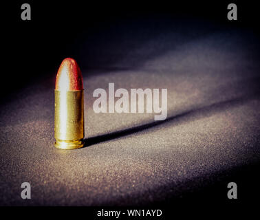 Einen einzigen Ständigen 9 mm bullet mit dramatischen Seite Licht und Schatten Stockfoto