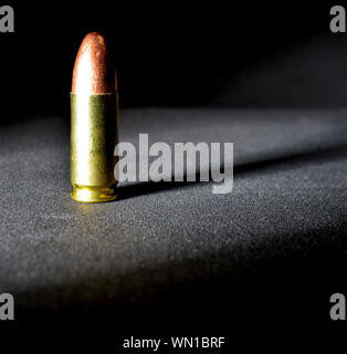 Einen einzigen Ständigen 9 mm bullet mit dramatischen Seite Licht und Schatten Stockfoto