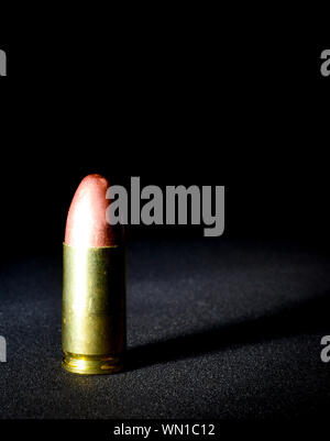 Einen einzigen Ständigen 9 mm bullet mit dramatischen Seite Licht und Schatten Stockfoto