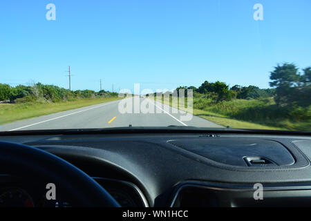 Blick aus der Frontscheibe eines Autos nach unten Reisen NC-12 auf den Outer Banks von North Carolina. Stockfoto