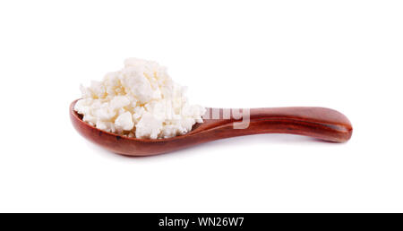 Quark in einem Kochlöffel auf weißem Hintergrund. Stockfoto