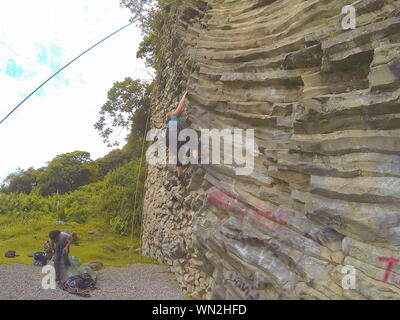 Klettern von Basaltfelsen in Boquete, Panama. Glattes und rutschiges Top-Roaming nur während des Urlaubs in Mittelamerika. Stockfoto