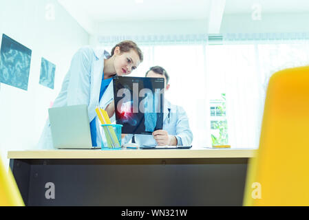 Erleben sie männliche und weibliche Ärzte Orthopädie und Team Experten diskutieren x-ray film, Chirurgie mit der Auslegung einer x-ray im Operationssaal in der Ho Stockfoto