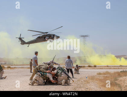 Jordan Soldaten, mit 7. mechanisierten Bataillons, 48th mechanisierte Brigade, decken ein fiktiv verletzte Soldat der US-Armee, mit der 1. Staffel, 102 Cavalry Regiment, 44th Infantry Brigade Combat Team der 42th Infantry Division, New Jersey National Guard zu schützen, wie ein UH-60 Black Hawk landet während der medizinischen Evakuierung Ausbildung, Teil des Jordan operativen Engagement Programm an die Gemeinsame Ausbildung Center-Jordan August 27, 2019. Die Armee ist die Optimierung der Interoperabilität mit allen unseren Verbündeten und Partnern Allianzen zu stärken und eine wirksamere operative Maßnahmen liefern. (U.S. Armee Foto von SG Stockfoto