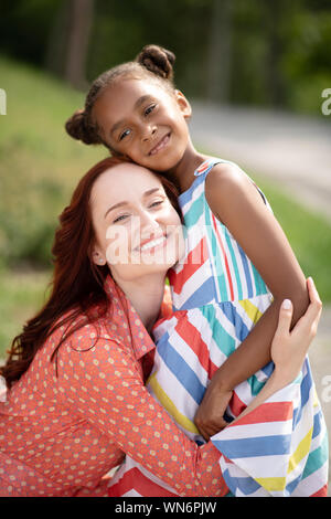 Strahlend schöne Mamma ihr süßen Tochter umarmen Stockfoto