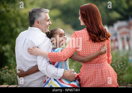 Annahme durch den Mädchen das Gefühl glücklich während der Sitzung ihre neuen Eltern Stockfoto