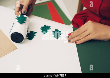 Das Mädchen am Tisch macht Weihnachten Geschenke. Hand Made Stockfoto