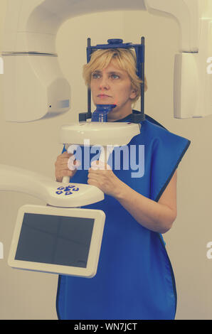 45 50-jährige Frau erfährt eine Röntgenuntersuchung von Ober- und Unterkiefer. Der Kegelstrahl-computertomografie. Stockfoto