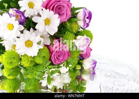 Blumenstrauß aus Rosen Blumen, weißen Chrysanthemen, dasies, grüne Blätter auf Spiegel mit verschüttetem Wasser tropfen Hintergrund isoliert, spase kopieren Stockfoto