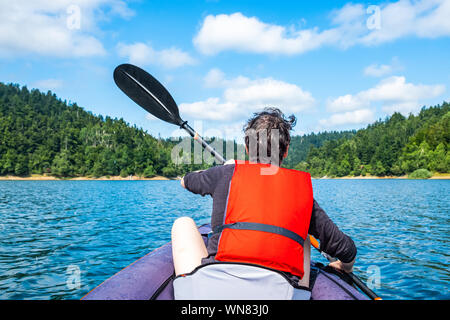 Frau Paddeln in aufblasbare Kajak fahren auf dem See, in Lokve Gorski kotar, Kroatien. Abenteuerliche Erfahrung in der wilden Natur. Stockfoto