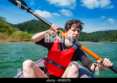 Frau Paddeln in aufblasbare Kajak fahren auf dem See, in Lokve Gorski kotar, Kroatien. Abenteuerliche Erfahrung in der wilden Natur. Stockfoto